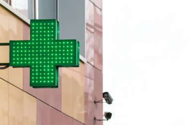 Kentsel eczane veya ilaç deposu işareti, led ekran yeşil çapraz şehir sokakta duvardaki