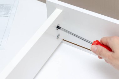 Montaj, beyaz mobilya bir tornavida kullanarak ayrıntılarını tighgting el