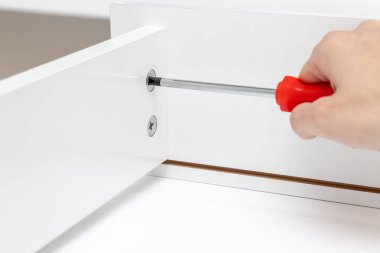 Montaj, beyaz mobilya bir tornavida kullanarak ayrıntılarını tighgting el