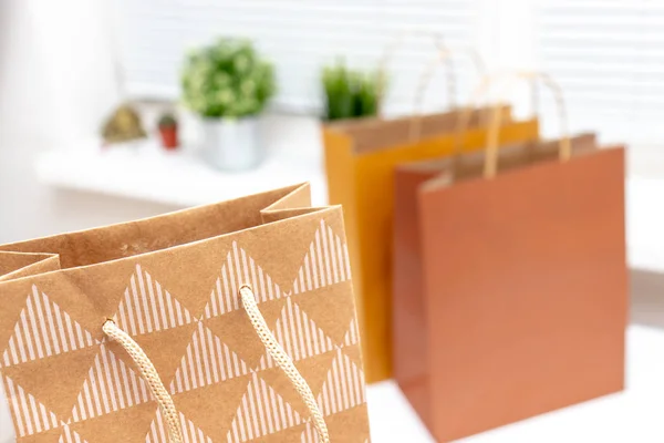 Bolsas de compras de papel marrón y beige en habitación moderna y luminosa con plantas verdes en un alféizar de ventana — Foto de Stock