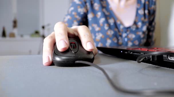 Mulher segurando um mouse de computador, clicando e rolando, close up. Senhora trabalhando no computador em casa — Vídeo de Stock