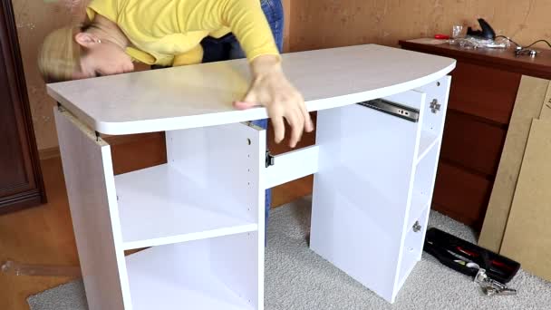 Mujer montando nuevos muebles blancos, ella poniendo una mesa en un nuevo tocador medio montado — Vídeo de stock