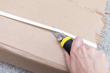 Bir karton kutu ile yeni mobilya yeni evine taşınıyor ve yeni mobilya satın alma inşaat veya office bıçakla - unboxing