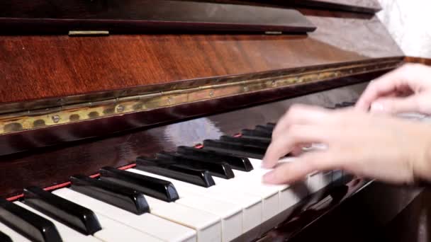 Руки білої жінки грають на піаніно, крупним планом, вид збоку — стокове відео