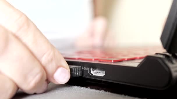 Woman hand plugging black USB cable to laptop and start typing on keyboard close up — Stock Video