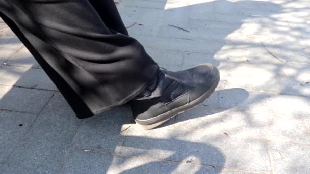 Pés em sapatos de inverno, pessoa descansando sentado em um banco em movimento e cruzando pernas, espaço de cópia — Vídeo de Stock