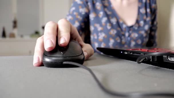 Mulher segurando um mouse de computador, clicando e rolando, close up. Senhora trabalhando no computador em casa — Vídeo de Stock