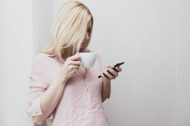 İş kadını sabah kahve içme ve akıllı telefon kullanma