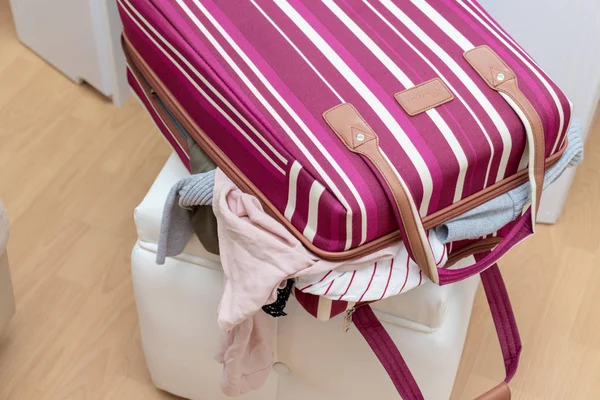 Rot und Weiß bunt gestreifte Gepäcktasche voller Kleidung-Reise-und Erlebniskonzept — Stockfoto