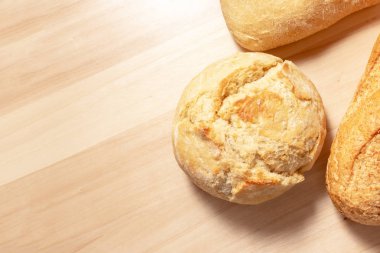 Ürün yelpazesine, kopya alanı ile ahşap masa arka plan üzerinde altın kabuk ile buğday pişmiş ekmek farklı türde