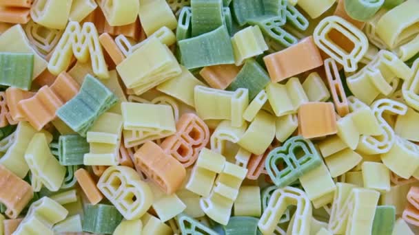 Alphabet kids italian pasta of different colors close up texture rotation background — Stock Video
