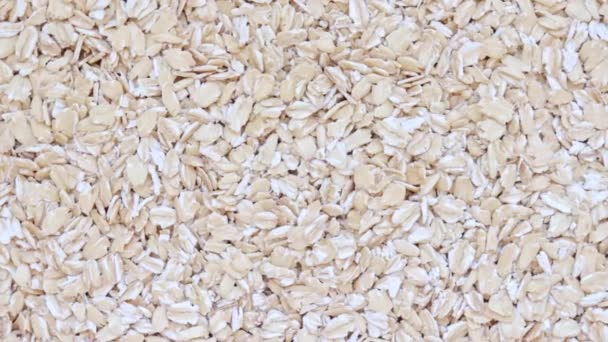 Raw oat flakes texture, healthy porridge rotation background, copy space — Stock Video