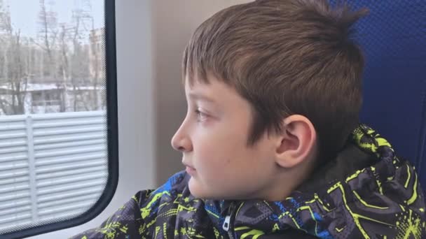 Porträtt av en ensam ledsen, deprimerad och apatiska preteen pojke rida på ett tåg, flyr han hemifrån — Stockvideo