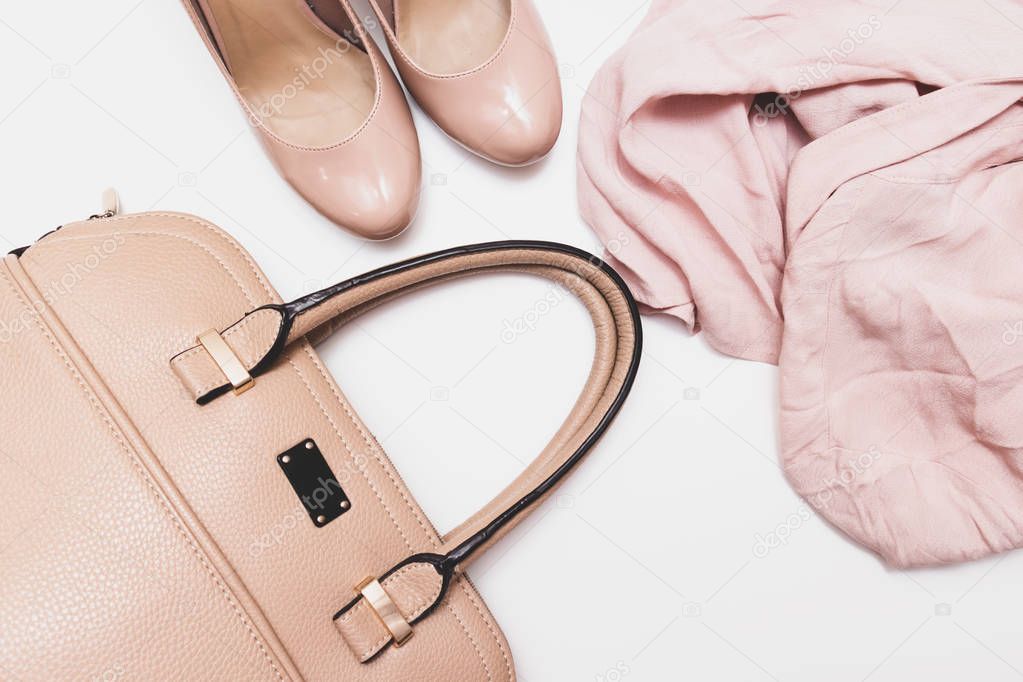 Fashionable concept, pastel beige shoes with high hills, leather bag and delicate blouse on white background, sale, diascount and shopping concept