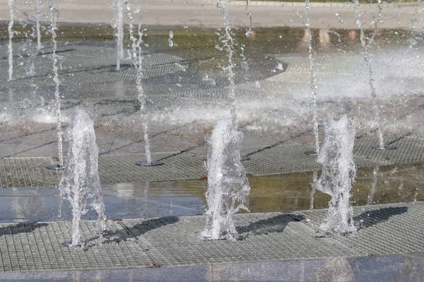 Flow splashes of water of city fountain, foam in jet of water. Fragment of recreation zone of the city park — Stock Photo, Image