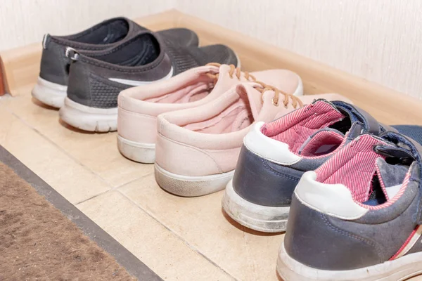 Три пары повседневной обуви - ботинки, кроссовки, кроссовки в коридоре — стоковое фото