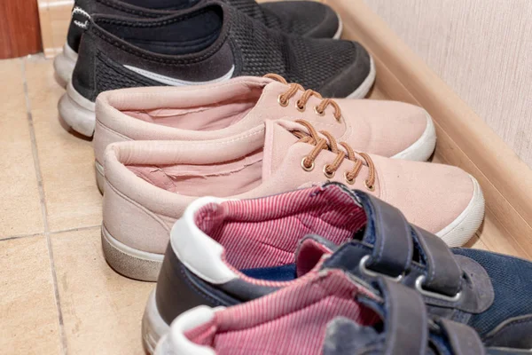 Three pairs of casual shoes - boots, sneakers, running shoes in the hallway — Stock Photo, Image