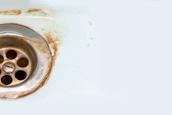 Dirty sink drain mesh, hole with limescale or lime scale and rust on it close up, dirty rusty bathroom washbowl with copy space