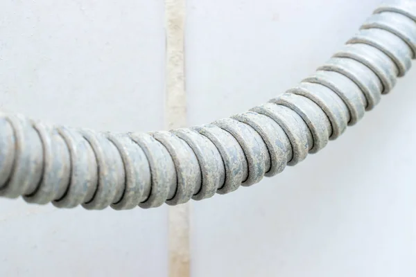 Detail of dirty calcified shower hose with limescale or lime scale on it, close up