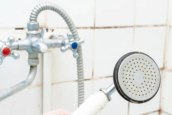 Cabezal de ducha viejo sucio cerca con cal y calcificado, mezclador de ducha oxidada y azulejos de molde en el fondo, concepto de baño de limpieza — Foto de Stock