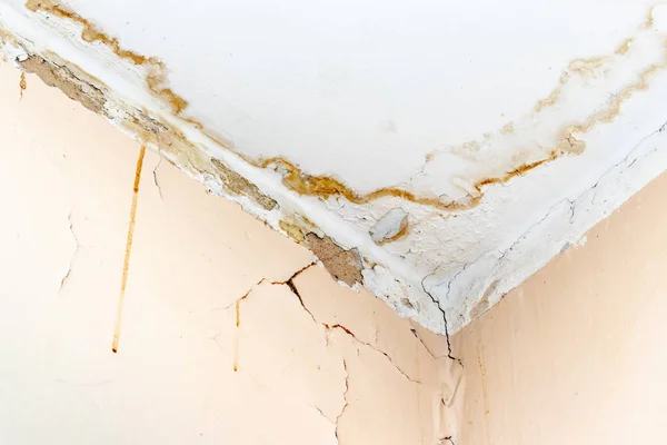 Rain water leaks on the ceiling because of damaged roof causing decay, peeling paint and moldy — Stock Photo, Image