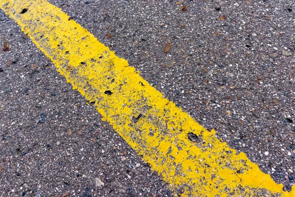 Yellow solid line, grunge single road marking on asphalt, background with copy space — Stock Photo, Image