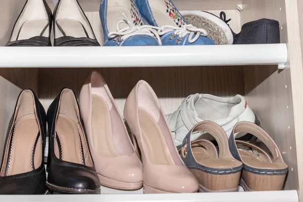 Shelves with woman old used shoes collection, standing messy in wardrobe, closet — Stock Photo, Image