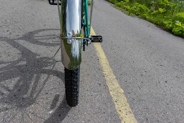 黄色の線の道路標示、ホイールクローズアップ、カントリーバイクの乗り心地と走行コンセプトを持つアスファルト道路に立つ自転車 — ストック写真