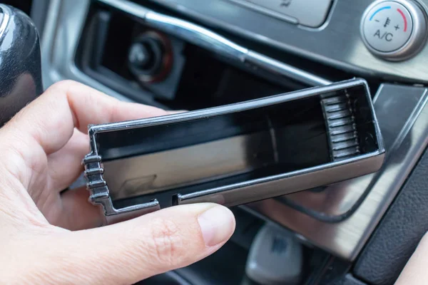 Una mano de un conductor sosteniendo un cenicero de plástico limpio lavado coche vacío, dejar de fumar en el coche — Foto de Stock