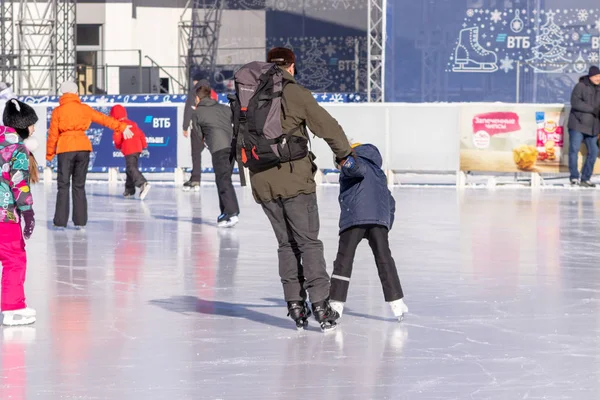 MOSCOU, RUSSIE - 02 MARS 2019 : Des personnes portant des vêtements d'hiver, un père et ses enfants patinant sur une patinoire d'hiver, des loisirs en famille et des activités sportives pendant les vacances de Noël — Photo