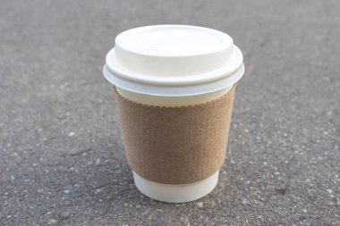 Şehir şehir parkında asfalt arka plan üzerinde beyaz fincan ile kraft tek kullanımlık paket kağıt fincan, şehir parkında yaz kahve molası