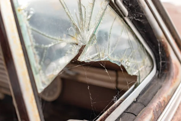 Janela de vidro quebrada de um velho carro enferrujado com uma teia de aranha nele — Fotografia de Stock