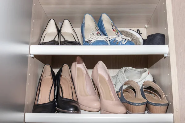 Shelves with woman old used shoes collection, standing messy in wardrobe, closet — Stock Photo, Image
