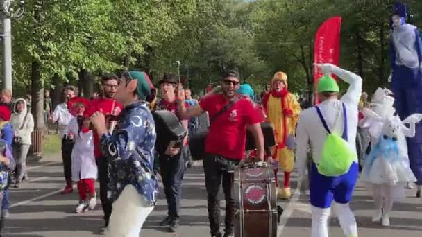 Moscú, Rusia - 14 de septiembre de 2019: Festival de payasos en la ciudad, payasos con ropa colorida y con un maquillaje brillante y músicos callejeros desfilan por la calle y hacen caras divertidas — Vídeos de Stock