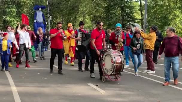 Moscú, Rusia - 14 de septiembre de 2019: Festival de payasos en la ciudad, payasos con ropa colorida y con un maquillaje brillante y músicos callejeros desfilan por la calle y hacen caras divertidas — Vídeos de Stock