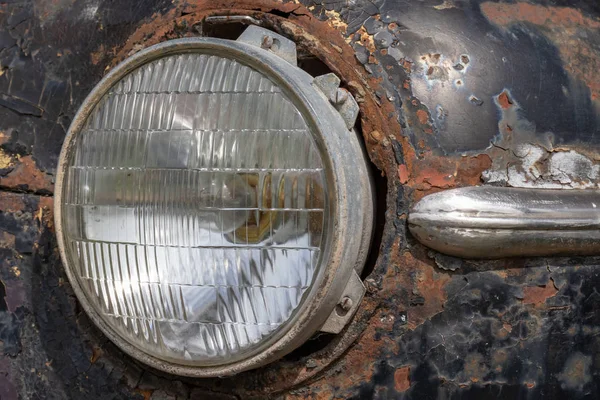 Farol de um velho carro enferrujado abandonado, utilização e conceito de sucata — Fotografia de Stock