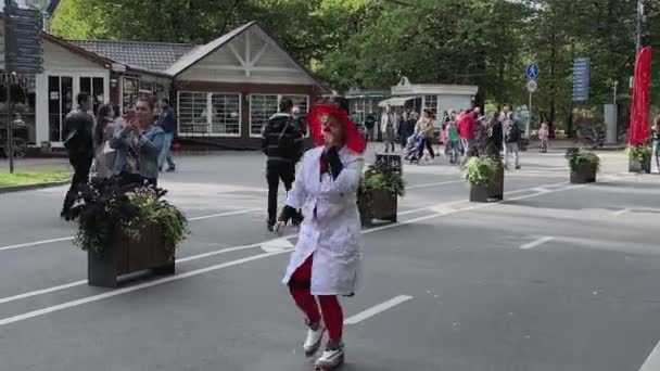 Moscou, Russie - 14 septembre 2019 : Festival de clowns dans la ville, clown femme en vêtements colorés et avec un maquillage lumineux qui passe et fait des grimaces et des poses drôles — Video