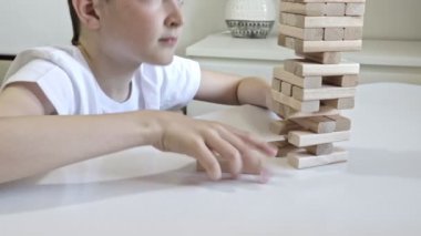 Bir preteen kafkas çocuk fiziksel ve zihinsel beceri ve eğlence ve kule düşen, sonunda kırma pratik için annesi ile ahşap blok kule tahta oyunu oynarken