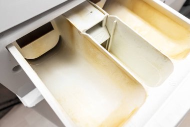 Kirli, küflü çamaşır makinesi deterjanı ve kumaş kremi kutusunun çekmecesini kapat. Küf, pas ve kireç rengi çamaşır makinesi tepsisi. Ev aletleri periyodik bakım