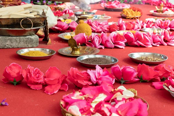 Indian wedding ceremony, decorations for traditional ethnic rituals for marriage, fire burning, flowers and statuettes of the deity on red carpet — Stock Photo, Image