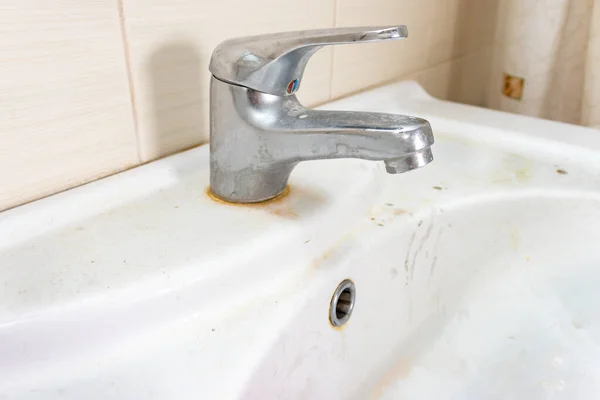 Lavabo viejo sucio con manchas de óxido, cal y manchas de jabón en el baño con un grifo, grifo de agua —  Fotos de Stock