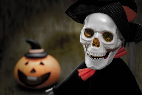 Halloween card with spooky skeleton and orange pumpkin on dark background