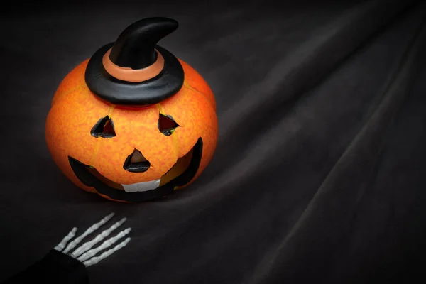 Calabaza de Halloween con cara sonriente espeluznante sobre fondo negro oscuro wiyh espacio de copia —  Fotos de Stock