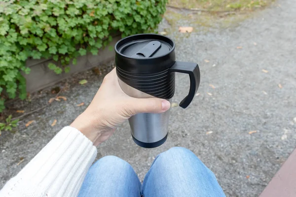 Женщина держит металлический термостат с горячим напитком, чаем или кофе — стоковое фото