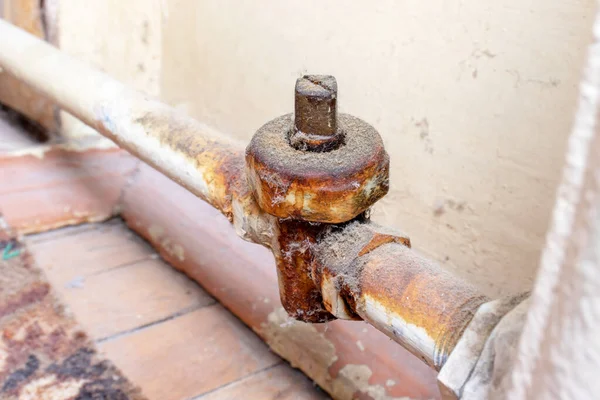 Старый ржавый нагревательный клапан на ржавом трубопроводе отопительного аккумулятора должен быть заменен водопроводчиком — стоковое фото