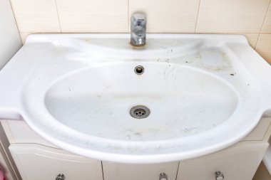 Pas lekeleri, kireç boyası ve banyoda musluğu olan eski kirli lavabo, su musluğu.