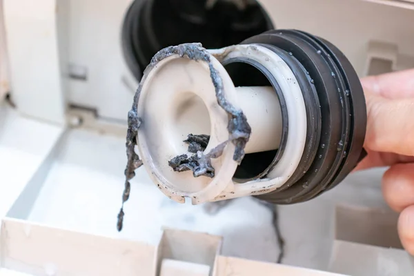 Проверка грязных засоренных фильтров дренажных насосов стиральной машины — стоковое фото