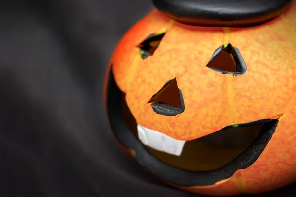 Calabaza de Halloween con cara sonriente espeluznante sobre fondo negro oscuro wiyh espacio de copia —  Fotos de Stock