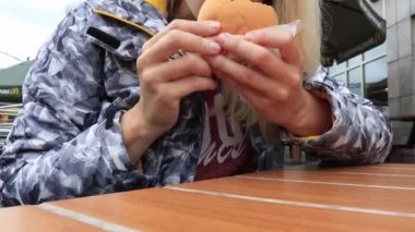 Moskova, Rusya - 2 Ağustos 2019 McDonalds restoranında çizburger menüsü yiyen genç bir kadın