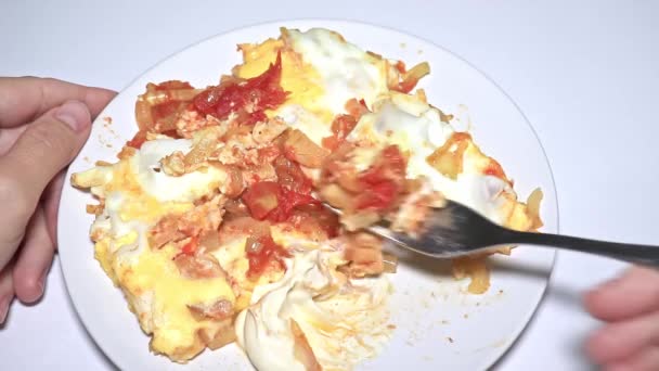 Frau isst Omelett, Rührei mit gebratenen Tomaten und Zwiebeln aus nächster Nähe — Stockvideo